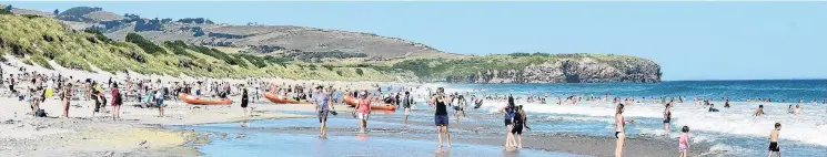  ?? PHOTO PETER MCINTOSH ?? Summer sizzler . . . Large crowds gather at St Kilda Beach after another hot summer day in Dunedin.