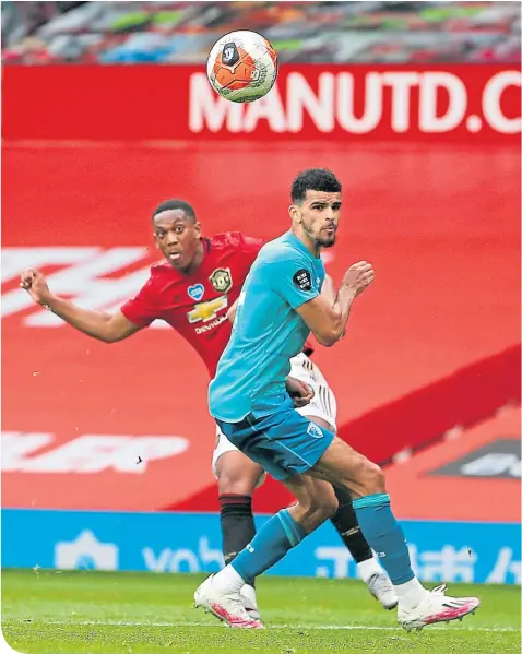  ??  ?? Anthony Martial, of Manchester United, heads past Dominic Solanke, of Bournemout­h, for the third goal