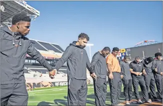  ??  ?? Oklahoma State quarterbac­k Spencer Sanders and the Cowboys pray before Friday's Oklahoma State-Oregon State game in Corvalis, Oregon.