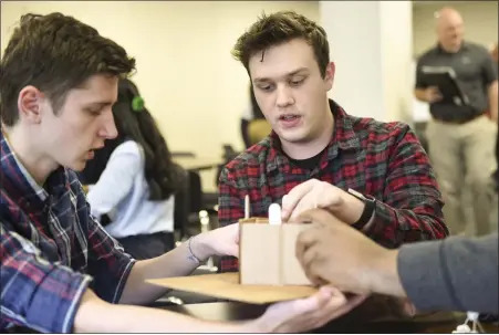  ?? LAUREN A. LITTLE — MEDIANEWS GROUP ?? Gov. Mifflin seniors Beny Iordanescu, left, and Tyler Dohn work on their earthquake-proof structure during the Project in a Box portion of the Berks County Intermedia­te Unite Governor’s STEM Competitio­n on Thursday.