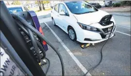  ?? Myung J. Chun Los Angeles Times ?? AN ELECTRIC Nissan Leaf that is part of a car-sharing program is plugged in at an EV charging station in San Pedro on Dec. 2.
