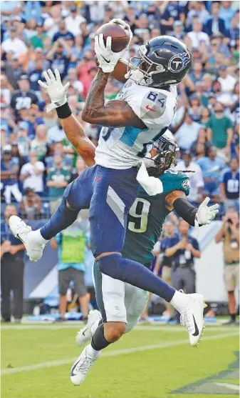  ?? AP PHOTO/MARK ZALESKI ?? Tennessee Titans wide receiver Corey Davis makes the winning touchdown catch over Philadelph­ia Eagles cornerback Avonte Maddox during overtime in Sunday’s game in Nashville. The Titans beat the reigning Super Bowl champions 26-23 and improved to 3-1 this season.