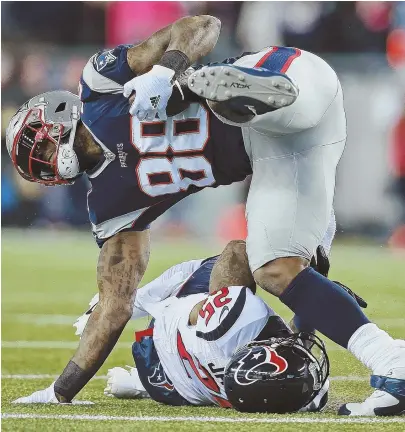  ?? sTaff phoTo By MaTT sToNE ?? FIGHTING FOR EVERY YARD: Tight end Martellus Bennett is upended by Houston Texans cornerback Kareem Jackson during the Patriots’ 34-16 divisional round victory last night at Gillette Stadium.