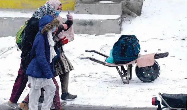 ?? Agence France-presse ?? ↑
Girls walk through a street as it snows in Skardu, Gilgit-baltistan, on Saturday.