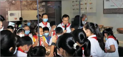  ?? PROVIDED TO CHINA DAILY ?? Henan Museum curator Ma Xiaolin explains exhibits to visiting students during summer activities in August 2022.