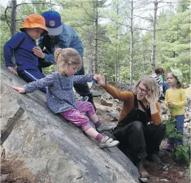  ?? FRED CHARTRAND/The Canadian Press ?? Marlene Power, centre, executive director at the Forest School Canada, teaches toddlers how to rock-climb.