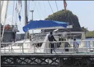  ?? (AP/Kenton X. Chance) ?? Investigat­ors from Grenada and St. Vincent and the Grenadines stand aboard the yacht “Simplicity,” that they say was hijacked by 3 escaped prisoners with two people aboard, now anchored at the St. Vincent and the Grenadines Coastguard Service Calliaqua Base in Calliaqua, St. Vincent, on Friday.