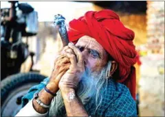  ?? CHANDAN KHANNA/AFP ?? Camel herdsman Lakshman Raika smokes a chillum pipe at his farm in Rani village in India’s western Rajasthan state.