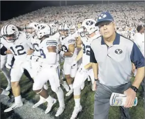  ?? Rick Bowmer
Associated Press ?? BRIGHAM YOUNG Coach Bronco Mendenhall leads his team on the field. The No. 19 Cougars have beaten Nebraska and Boise State to begin the season 2-0.