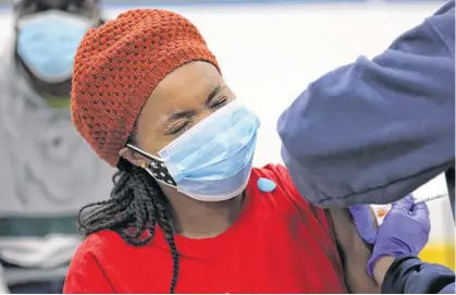  ?? REUTERS ?? A woman reacts while being inoculated with Pfizer vaccine by a health worker from Humber River Hospital during a vaccinatio­n clinic for residents 18 years of age and older who live in coronaviru­s disease “hot spots” at Downsview Arena in Toronto.