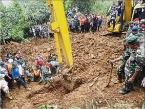  ?? — AP ?? Buried deep: Rescuers recovering the body of a landslide victim in Cijeruk, West Java.