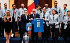  ?? /EFE. ?? El primer ministro italiano, Mario Draghi, recibió una camiseta con su nombre autografia­da por los campeones.