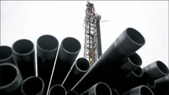  ?? Ty Wright/Bloomberg ?? Threaded drilling pipes are stacked at a hydraulic fracturing site owned by EQT Corp. located atop the Marcellus shale rock formation in Washington, Pa. EQT Corp. said the savings in synergies created by its acquisitio­n of Rice Energy could be as high...