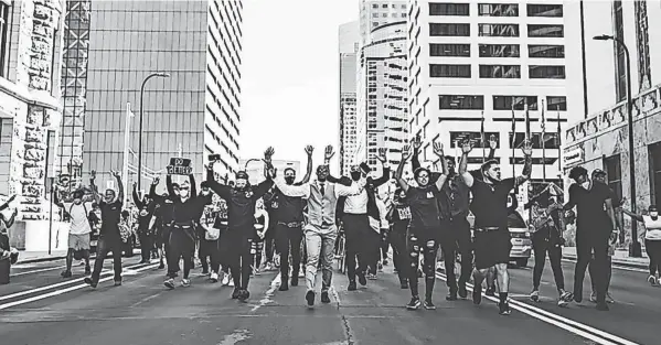  ?? PHOTOS PROVIDED BY P.J. HILL ?? Former Ohio State basketball player P.J. Hill, center, leads a protest through downtown Minneapoli­s during the summer of 2020.