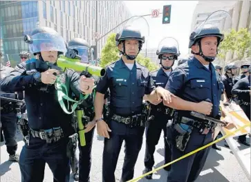  ?? Luis Sinco Los Angeles Times ?? LAPD OFFICERS form a wall between pro- and anti-Trump protesters at the conclusion of May Day marches and rallies on Monday. New directives address deployment policies, data reporting and other issues.