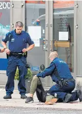  ??  ?? Police surround an injured man yesterday