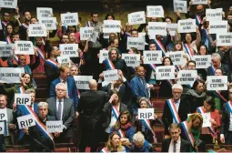  ?? LEWIS JOLY/AP ?? Lawmakers protest Monday at the National Assembly in Paris against President Emmanuel Macron’s reforms to raise the retirement age in France from 62 to 64 .