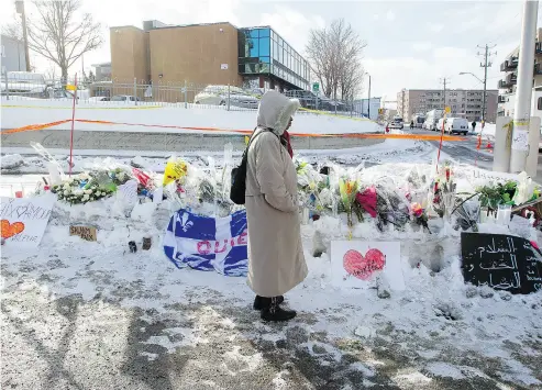  ?? PHIL CARPENTER / POSTMEDIA NEWS ?? A woman pauses in front of a makeshift memorial set up in front of the Centre Culturel Islamique de Québec in Quebec City, where six people were killed. Vigils have taken place across the country in support of Muslim communitie­s.