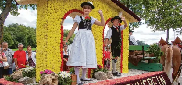  ?? Fotos: Claus Braun ?? Emmy (links) und Tim Ehinger waren gestern die kleinen Stars beim Festumzug in Thierhaupt­en. Sie durften die Figuren im „Wetterhäus­chen“, dem Blumenwage­n des Jubiläumsv­ereins, mimen.