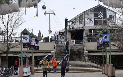  ?? ?? Skiers walk through Gondola Plaza in Aspen on March 29. A dozen mountain resort counties such as Pitkin County, home to Aspen, received $ 11,652 per resident. Pitkin was tops in the state, with $ 19,545 per capita in funding, followed by San Miguel, home to Telluride, at $ 17,286 per resident. By contrast, non- resort rural counties received $ 7,202 per resident.