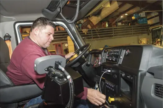  ?? Photos by Michael Derr ?? Michael DiCicco, director of the Narraganse­tt Department of Public Works, prepares to leave the town garage in a plow truck during Saturday’s blizzard. Below, DiCicco’s truck.