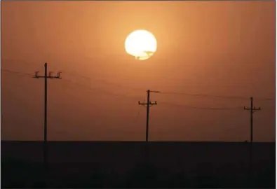  ?? (Bloomberg/Bing Guan) ?? The sun rises over power lines near Imperial, Calif., in August 2020.