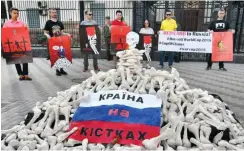  ?? Foto: AFP/Genya Savilov ?? Aus Solidaritä­t mit Oleh Senzow fordern Demonstran­ten vor der russischen Botschaft in Kiew auf martialisc­he Weise einen WM-Boykott.