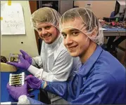  ?? GEORGIA TECH ?? Georgia Tech graduate students Travis Imken (left) and Terry Stevenson hold a propulsion system they designed and built that is similar to those that will be used on the NASA BioSentine­l mission on Artemis 1.