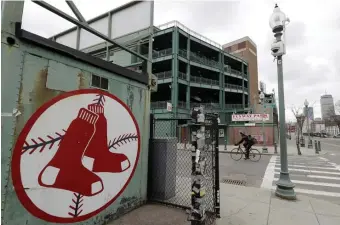  ?? AP FILe PHOTOs ?? READY FOR ACTION: New York Yankees president Randy Levine is calling on the players’ associatio­n to resume negotiatio­ns with MLB in order to get the pandemic-delayed season underway. At right, a cyclist rides past Fenway Park in March.