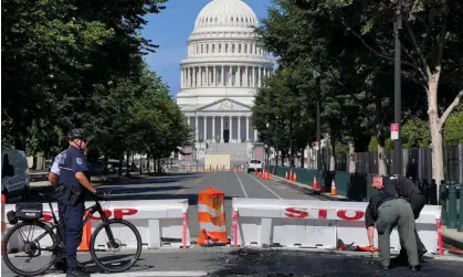  ?? Photograph: Daniel Slim/AFP/Getty Images ?? US Capitol police officers near a police barricade on Capitol Hill in Washington DC, on Sunday.A man died after a man drove his car into a barricade and firing shots into the air before turning his gun on himself.