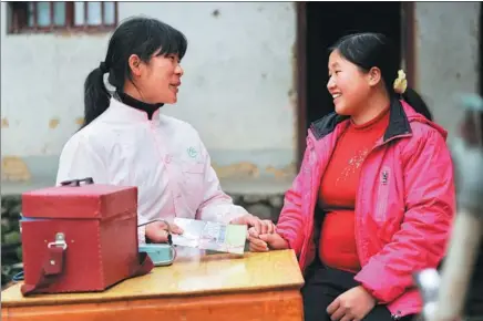  ?? ZHOU KE / XINHUA ?? A family planning officer explains a healthcare pamphlet to a pregnant woman in Zhengang, Jiangxi province