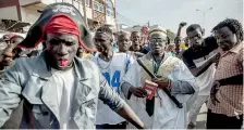  ??  ?? A man dressed like incumbent president Yahya Jammeh (C) parades with supporters of the newly elected president Adama Barrow as they celebrate his victory during the presidenti­al elections in Serekunda on December 2, AFP