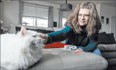  ?? Amanda Andrade-rhoades
The Associated Press ?? Donna Cooper pets her cat Cade at her home in Front Royal, Va. Cooper has heard that people gain back weight when they stop using drugs like Wegovy, but she hopes to be an exception. She’s on her last box of Wegovy injections. Once she’s done, Cooper said, she’ll just continue with a strict diet and exercise plan.