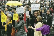  ?? — Reuters ?? Election committee members protest, demanding universal suffrage, as former chief secretary Carrie Lam declares her win as the chief executive in Hong Kong on Sunday.