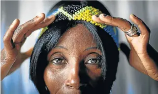  ?? /Daniel Born ?? New patterns: Mmalerato Rabotapi tries on a headband at a beading workshop in Orange Farm, southern Johannesbu­rg. Business and Arts SA believes in the power of business working with the creative sector.