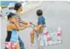  ?? The Associated Press ?? A woman pushes a shopping cart filled with water bottles in Puerto Rico on Thursday.