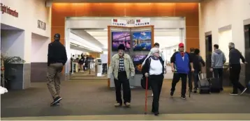  ?? STAFF PHOTO BY OLIVIA ROSS ?? Individual­s walk down the passenger terminal at Chattanoog­a Airport on Nov. 21.