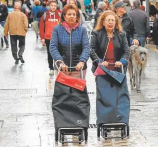  ?? // REUTERS ?? Dos mujeres avanzan con el carrito de la compra por las calles