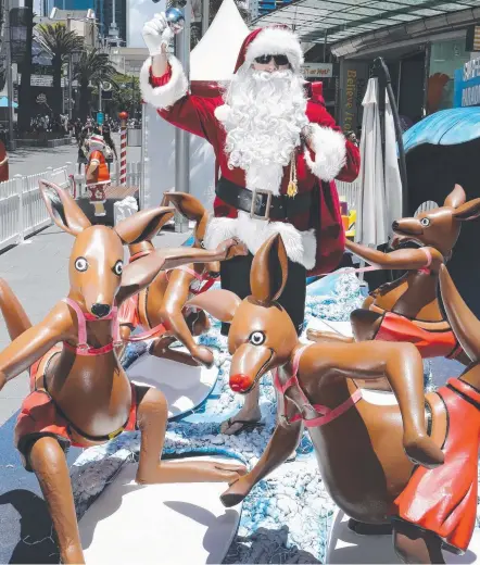  ?? Picture: GLENN HAMPSON ?? Santa gets into the Surfers Paradise spirit with his kangaroo mates.