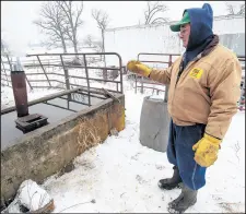  ?? KYLE TELECHAN/POST-TRIBUNE ?? Keith Gustafson, owner and farmer of Gustafson Farm in Porter Township, on Thursday points out a wood-fueled water heater that has been used by his family for generation­s.