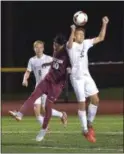  ?? PETE BANNAN — DIGITAL FIRST MEDIA ?? West Chester Henderson’s Joao Argolo is out jumped by Unionville’s (32) Kyle Ketterer Monday evening as the Warriors defeated Unionville 1-0 on a goal by Kevin Kiefer.