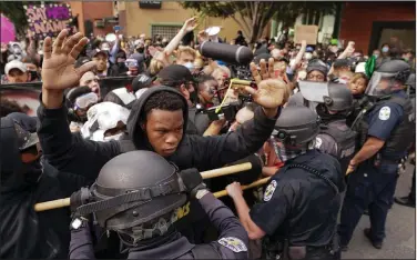  ?? (AP/John Minchillo) ?? Police officers and protesters converge during a demonstrat­ion Wednesday in Louisville, Ky. Protests turned violent later in the day, and two officers were wounded in a shooting.