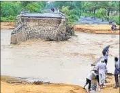  ??  ?? People watch as a small bridge on the Deesa Dhanera highway in Gujarat is washed away by floods on Tuesday. AP PHOTO