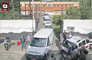  ?? AMANDA PEROBELLI / REEUTERS ?? Sao Paulo. Varios vehículos funerarios abandonan el colegio Raúl Brasil, donde ayer se produjo el tiroteo.