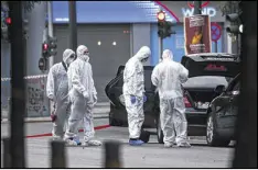  ?? YORGOS KARAHALIS / ASSOCIATED PRESS ?? Greek police experts search for evidence after a blast inside former Greek Prime Minister Lucas Papademos’ car Thursday in Athens. There was no immediate claim of responsibi­lity.