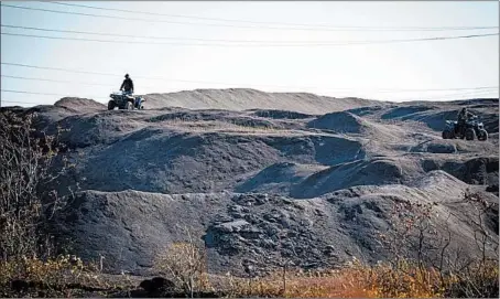  ?? E. JASONWAMBS­GANS/CHICAGO TRIBUNE ?? ATV riders cross slag heaps in the area south of 126th Place from Carondolet to Avenue O that was recently designated a Superfund cleanup site.