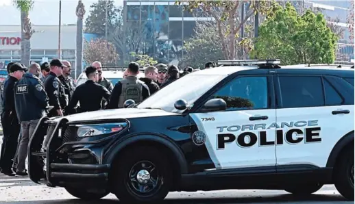  ?? FOTO: AFP ?? Oficiales de policía de Torrance y otras fuerzas del orden se reúnen después de irrumpir en una camioneta con un cuerpo en el asiento del conductor, era el del Huu Can Tran, de 72 años.