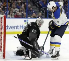  ?? Associated Press ?? Lightning goaltender Andrei Vasilevski­y makes a save against Blues left wing Pat Maroon in a 1-0 overtime loss Thursday. Tampa Bay has dropped two in a row but remains in control of the Atlantic Division with an NHL-high 82 points.