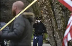  ?? MATTHEW DAE SMIT — LANSING STATE JOURNAL VIA AP ?? A Michigan State Police Trooper patrols April 23while a small caravan of protesters circle a neighborho­od near the Michigan Governor’s Mansion in Lansing.