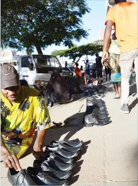  ??  ?? A shoemaker Mr Tawanda Gumbo arranges men’s shoes he makes for sale on a pavement along Leopold Takawira Avenue in Bulawayo.